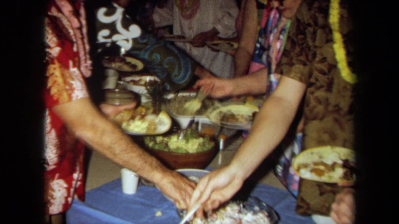 Close view of hands serving food onto plates at a buffet.
