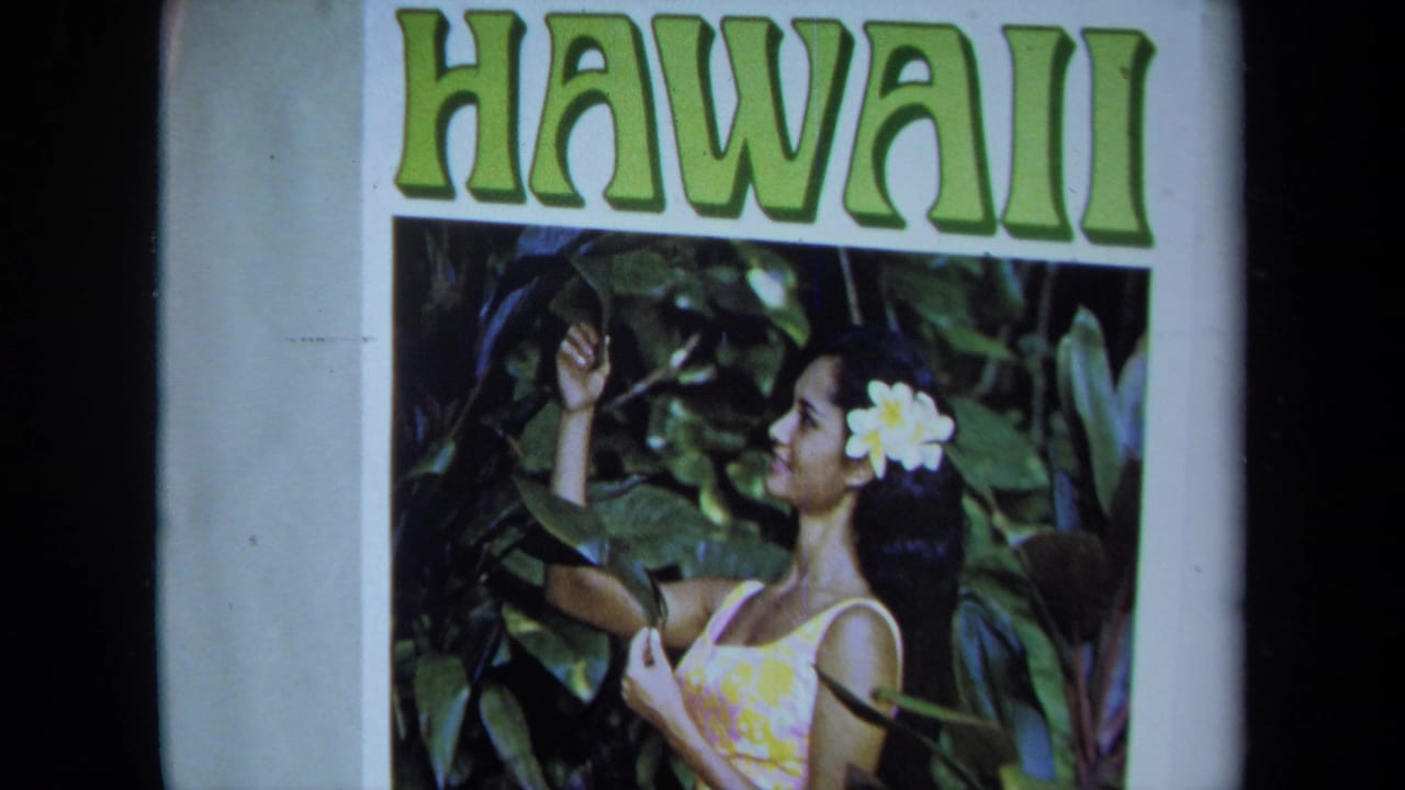 1971 California 8mm frame of a Hawaii poster showing a woman with a flower in her hair against dense green foliage.