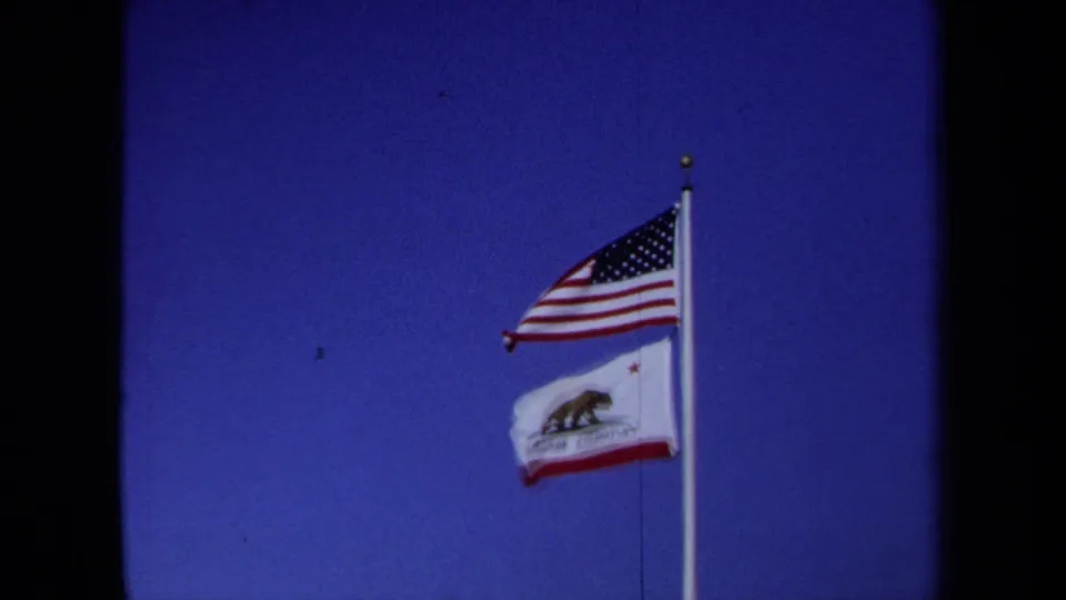 The U.S. flag flies above the California Republic flag in a 1971 California 8mm home-movie shot.