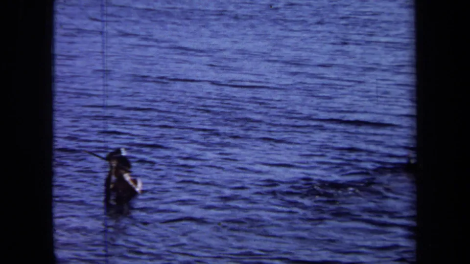 A person is visible in open water in the California 1971 home-movie clip, with another figure farther away near the surface.