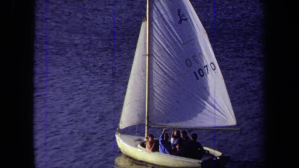 The final 1971 California frame shows passengers in the sailboat, with one person lifting an arm beneath the numbered sail.