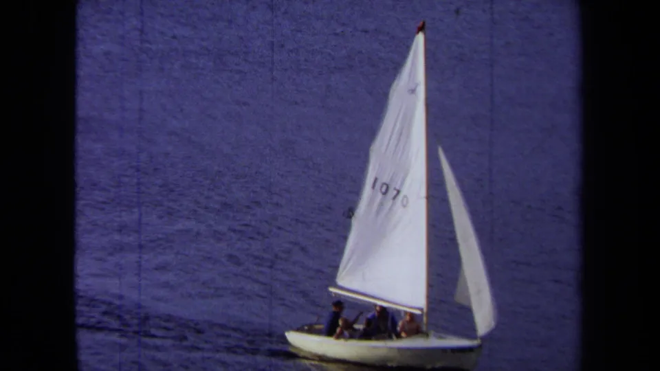 1971 California 8mm frame showing a small white sailboat with sail number 1070 moving across blue water.