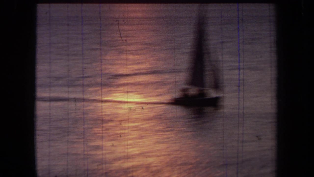 1971 California 8mm frame showing a sailboat in soft silhouette on reflective dusk water with visible film wear.