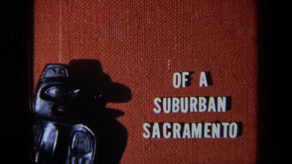 1971 California 8mm title frame with the carved figure partly visible and white text reading Of a Suburban Sacramento.