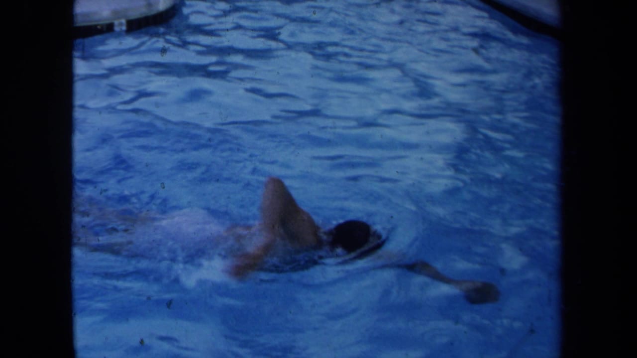 Adult swimmer turns to breathe while moving through a blue pool.