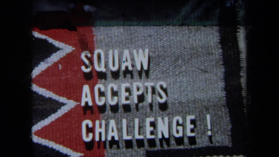 A home-movie title card reads SQUAW ACCEPTS CHALLENGE! in white letters on a red and gray textured background.