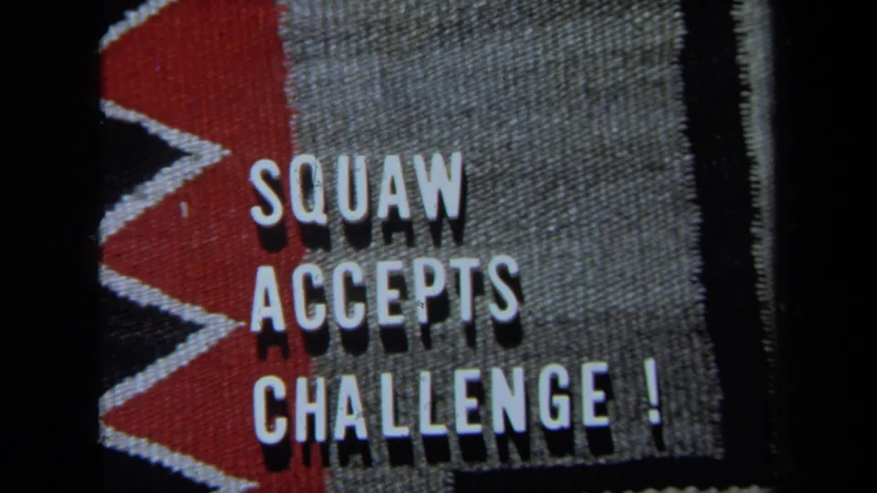 1971 8mm title card with bold white text reading SQUAW ACCEPTS CHALLENGE! on a red and gray patterned surface.