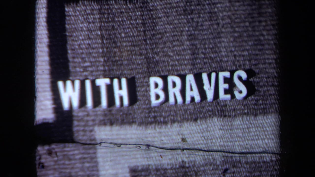 1971 California 8mm frame showing the phrase “WITH BRAVES” in white block letters on gray textured fabric.