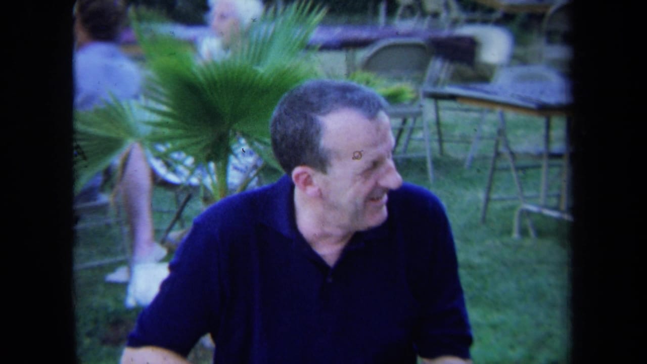 Seated man in a dark polo shirt turning right in an outdoor dining area.