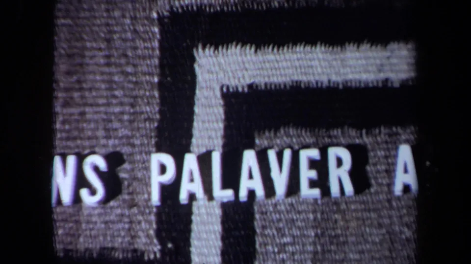 1971 8mm title-card frame showing cropped lettering including “PALAVER A” over a textured background.