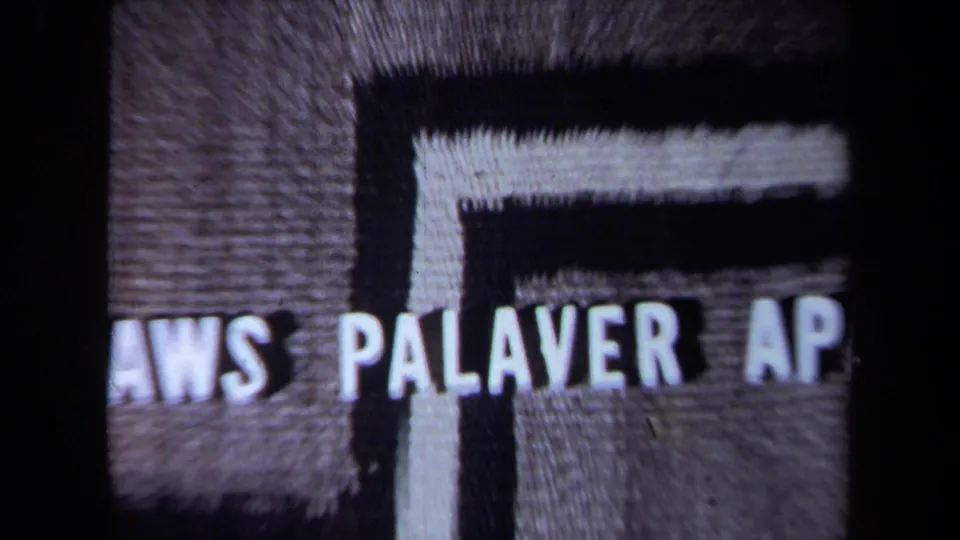 Cropped 8mm title-card frame with partial lettering reading “PALAVER AP” before the social scene.