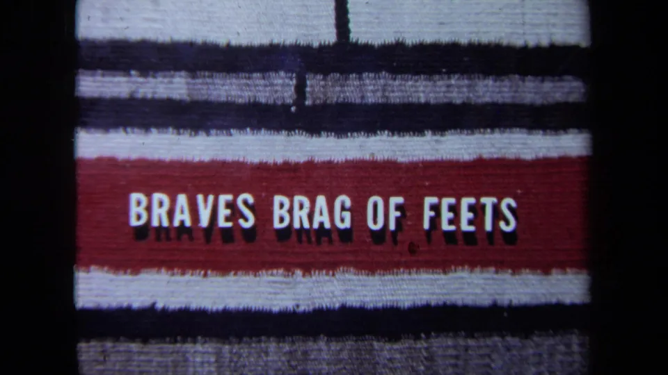 1971 California 8mm frame of a filmed television-style title card with the misspelled phrase BRAVES BRAG OF FEETS.