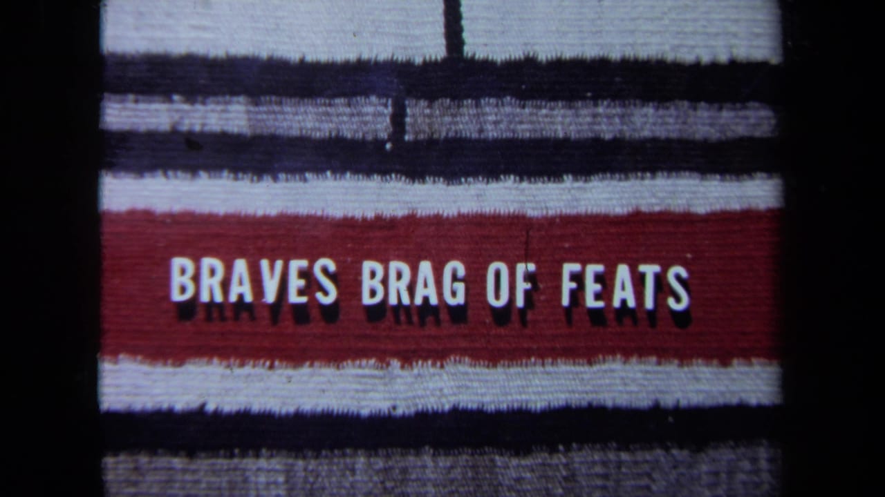 1971 California 8mm frame with a red-and-white sign reading "BRAVES BRAG OF FEATS" against dark film borders.