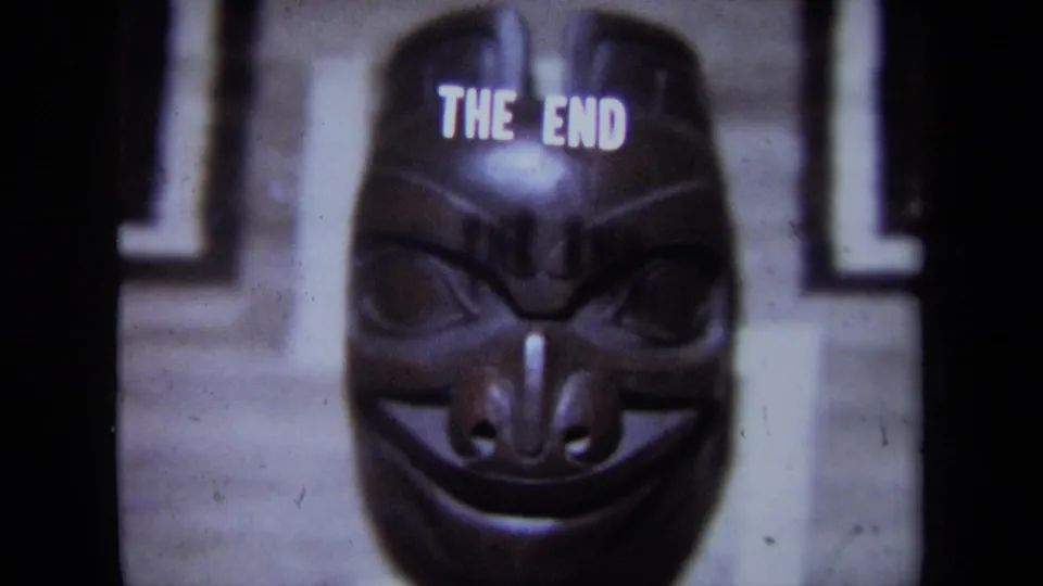 1971 California 8mm frame showing the carved mask below the ending title, with soft focus and film grain.