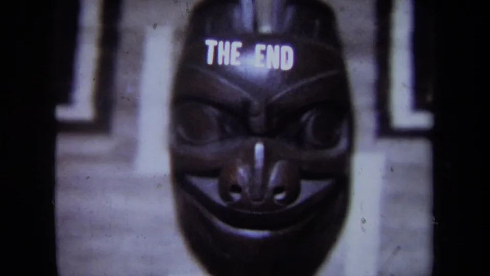 1971 California 8mm ending frame with a dark carved mask, visible grin, and THE END title above.