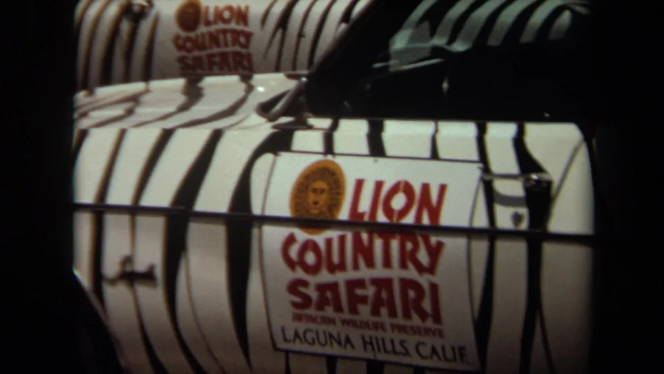 Close 8mm view of a Lion Country Safari vehicle door with zebra striping and Laguna Hills wording visible.