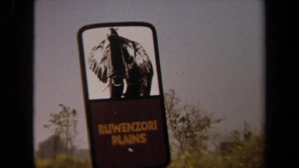 1971 Laguna Hills frame showing a Ruwenzori Plains sign with an elephant graphic, filmed from a visitor route in a wildlife park setting.