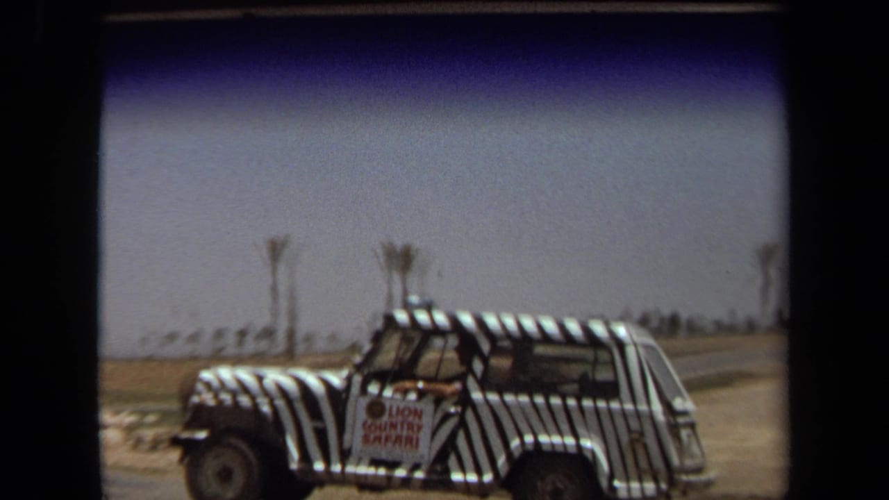 1971 Laguna Hills home-movie frame showing a zebra-striped safari vehicle with a Lion Country Safari sign under a bright sky.