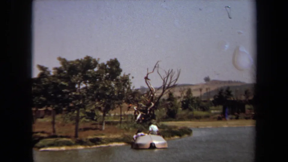 A landscaped water feature in 1971 Laguna Hills shows a small sculptural island form, trees, open lawn, and low hills in the background.