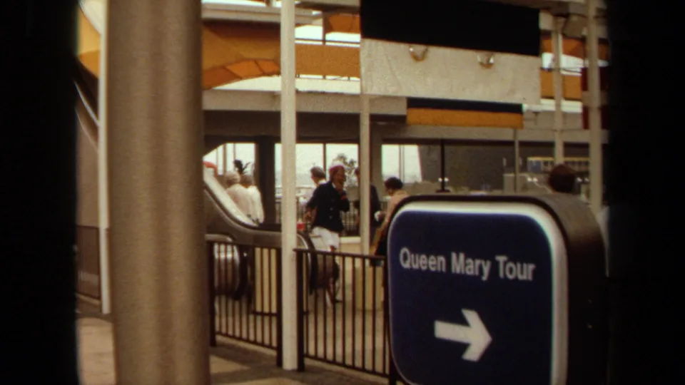 1971 Long Beach visitor-area view with a Queen Mary Tour sign, arrow, railings, columns, and several people near the entrance.