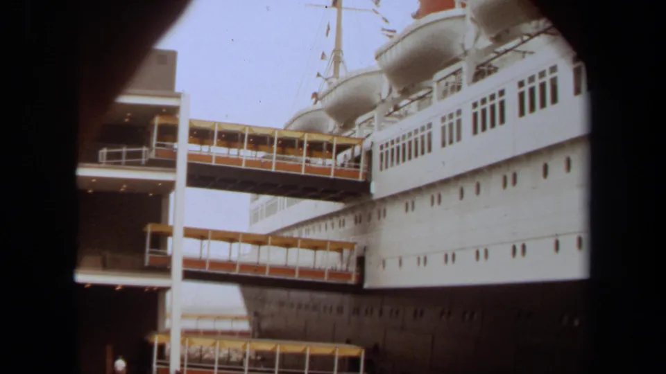 1971 Long Beach view of enclosed gangways leading from the terminal toward the white ocean liner.
