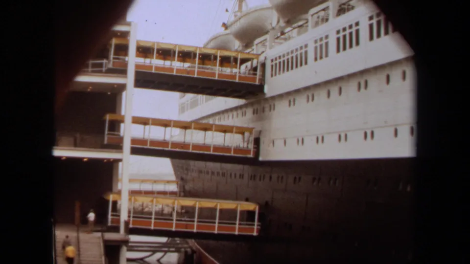 A 1971 Long Beach frame shows the ship's side, terminal bridges, and small people on the dock below.