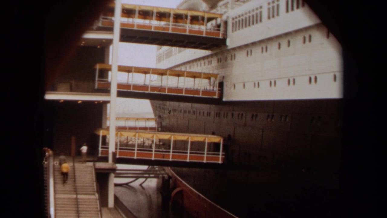 Long Beach, 1971 view of a docked passenger ship with covered boarding bridges and people visible near the stairs.