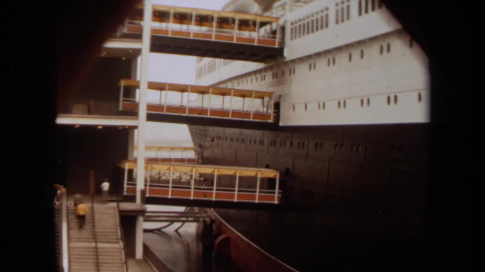 Long Beach, 1971 view of a docked passenger ship with covered boarding bridges and people visible near the stairs.