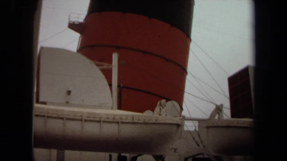 1971 Long Beach view of a passenger ship with a red-and-black smokestack, white structures, rigging lines, and lifeboat details.