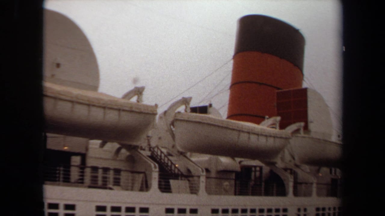 Passenger ship side with white lifeboats and a red-and-black smokestack under an overcast sky.