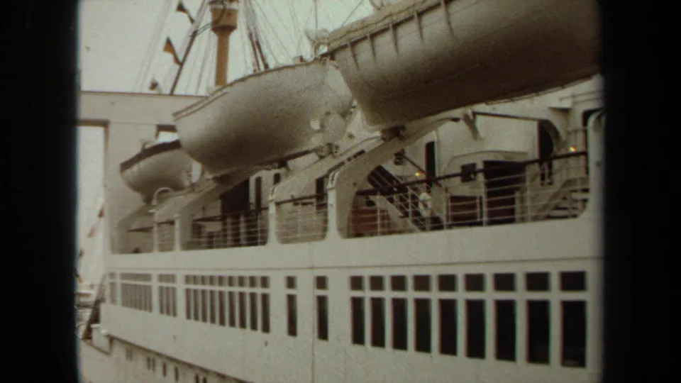 1971 Long Beach frame of a large white passenger ship, showing davit-mounted lifeboats, upper railings, and rectangular window rows.