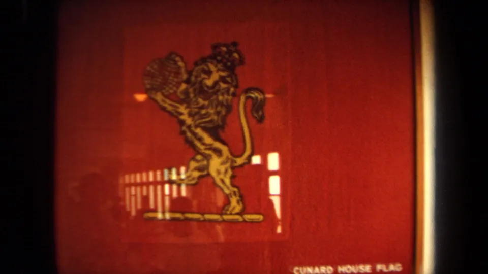 1971 shipboard close-up of the red Cunard House Flag display, showing the gold lion emblem, bright window reflections, and partial bottom text.