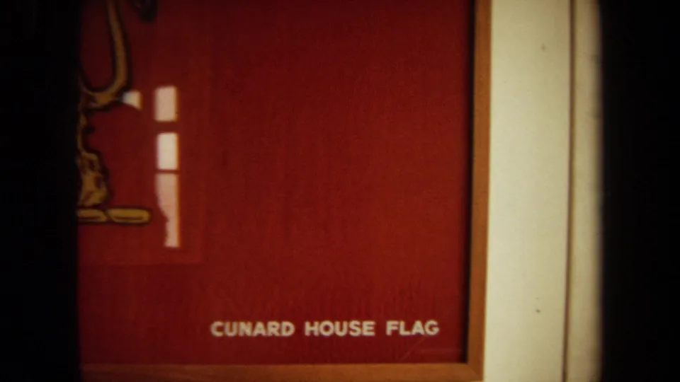 Cropped 1971 8mm view of the Cunard House Flag display, with the lion partly off frame and the words Cunard House Flag visible near the bottom.