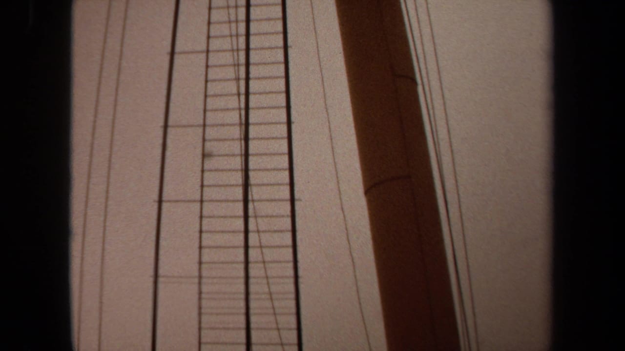 1971 Long Beach 8mm frame with a wooden mast, ladder structure, rigging wires, and dark frame borders from a low boat-side angle.