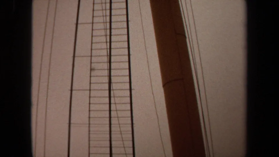 1971 Long Beach 8mm frame with a wooden mast, ladder structure, rigging wires, and dark frame borders from a low boat-side angle.