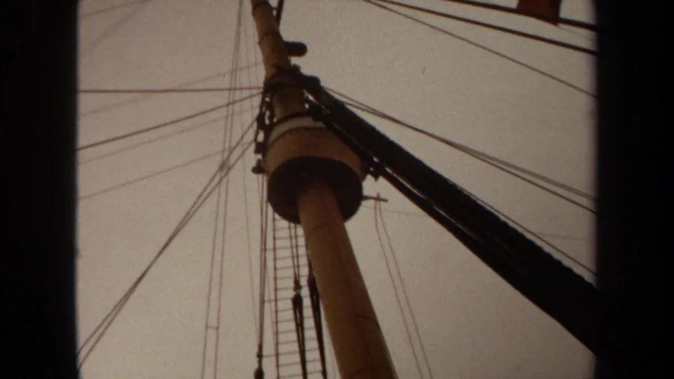 1971 Long Beach 8mm frame looking up at pole hardware, ladder rungs, bundled cable, and crossing wires against a faded sky.