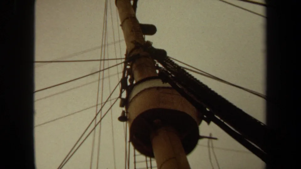 1971 Long Beach 8mm frame showing a closer upward view of the pole, circular mount, ladder, and overhead wiring.