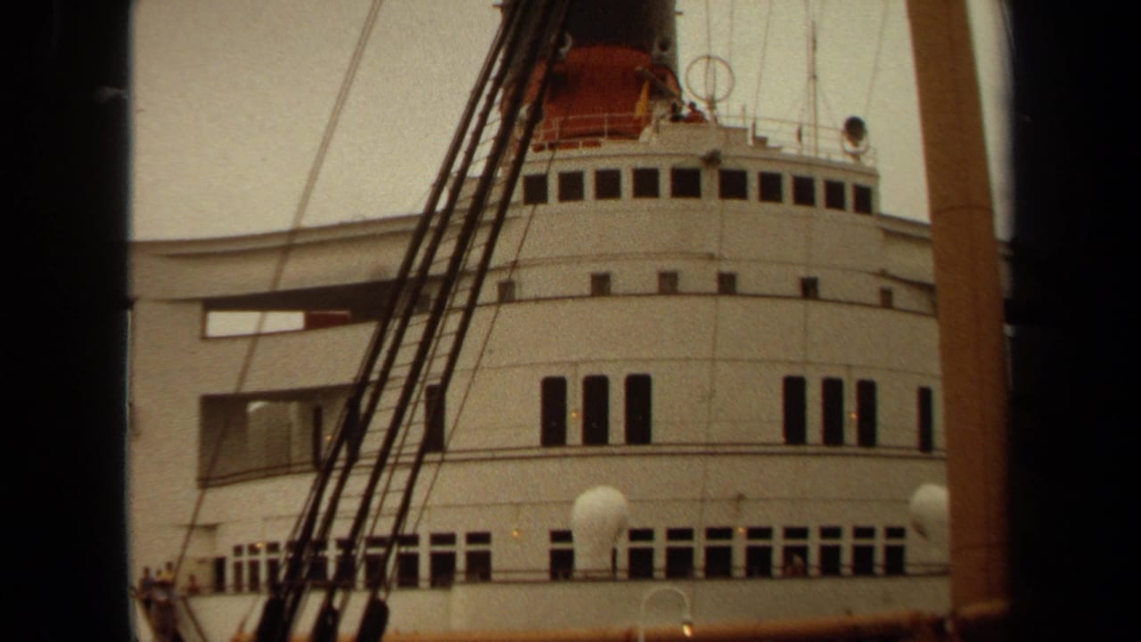 Ship bridge with dark window rows, rigging, and mast structures in front.