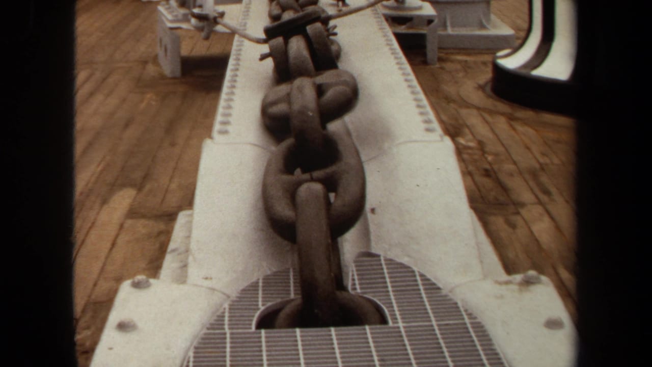Close view of a heavy anchor chain over white deck equipment in 1971 Long Beach home-movie footage.