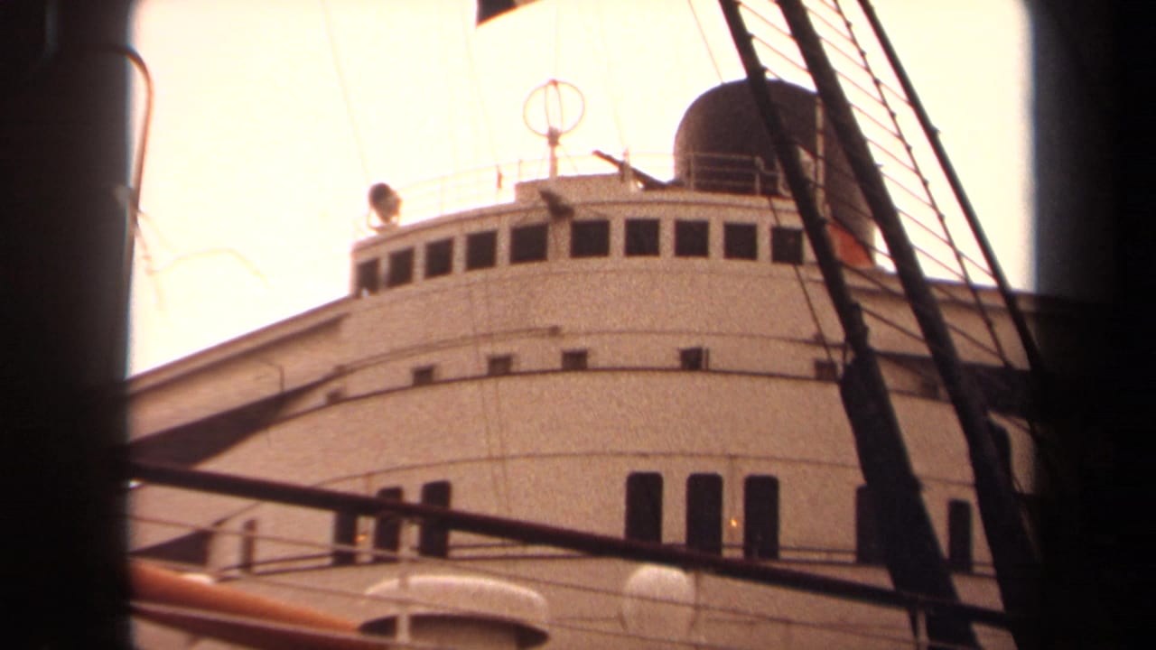 1971 Long Beach home-movie frame of a white passenger ship superstructure viewed through nearby vessel rigging.