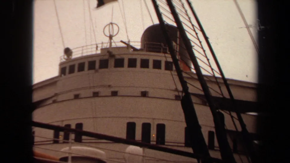 White passenger ship bridge and dark funnel at Long Beach, filmed through rigging on 8mm in 1971.