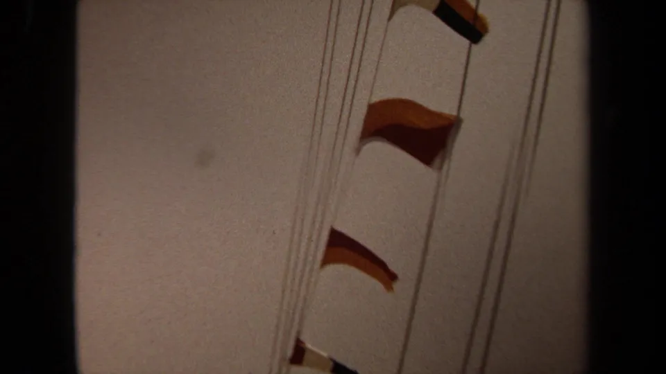 1971 Long Beach 8mm frame showing signal flags suspended from ship rigging in a close, handheld view.