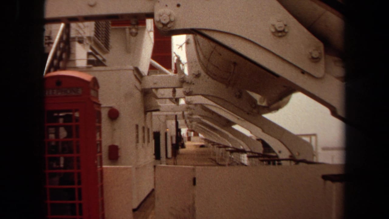 1971 cruise ship deck view near Long Beach showing a red telephone booth framed by white railings and large structural beams.