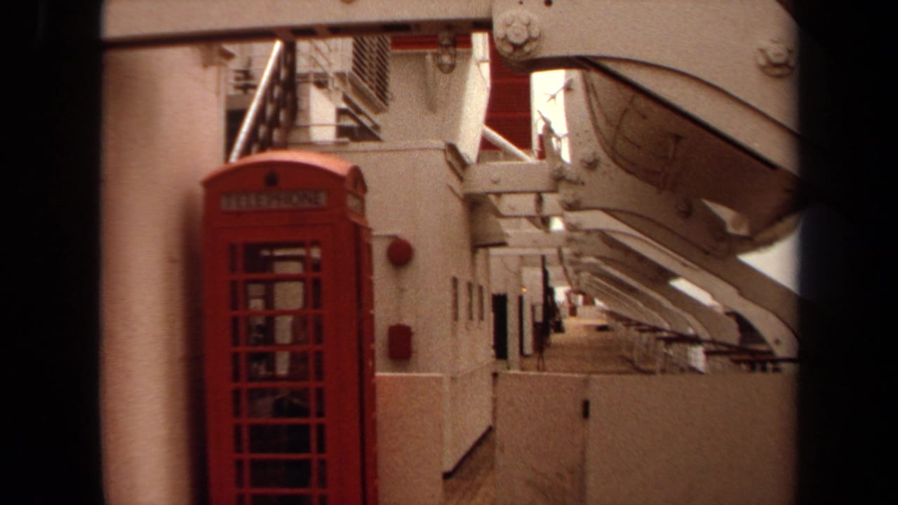 Red telephone booth and ship deck corridor seen between dark film-frame edges.
