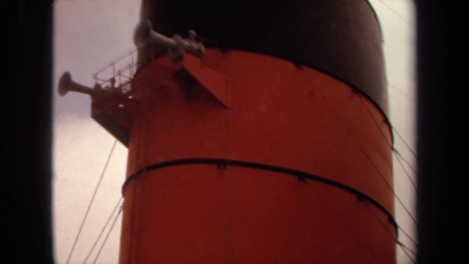 Close view of the upper red ship funnel with a horn platform, railings, and dark cap in 1971 Long Beach footage.