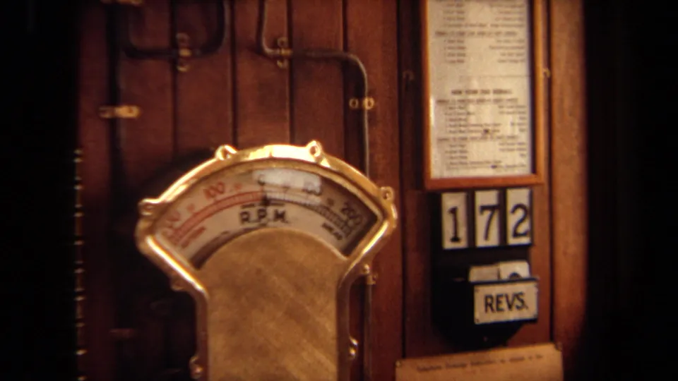 Close 1971 Long Beach frame of a brass R.P.M. dial beside a 172 display and REVS. label on a wooden panel.