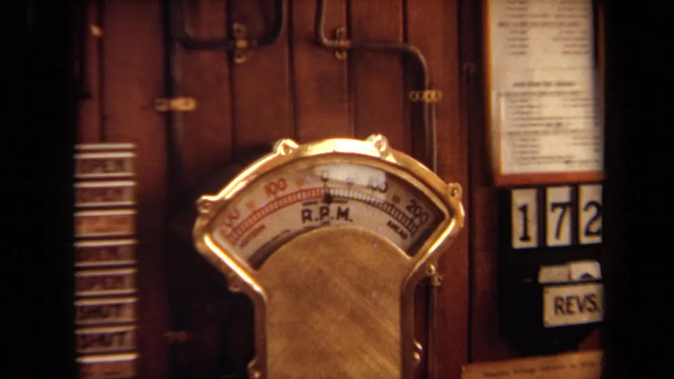 1971 8mm close-up of an analog R.P.M. gauge on a wooden control panel, with labels partly cropped by the frame.