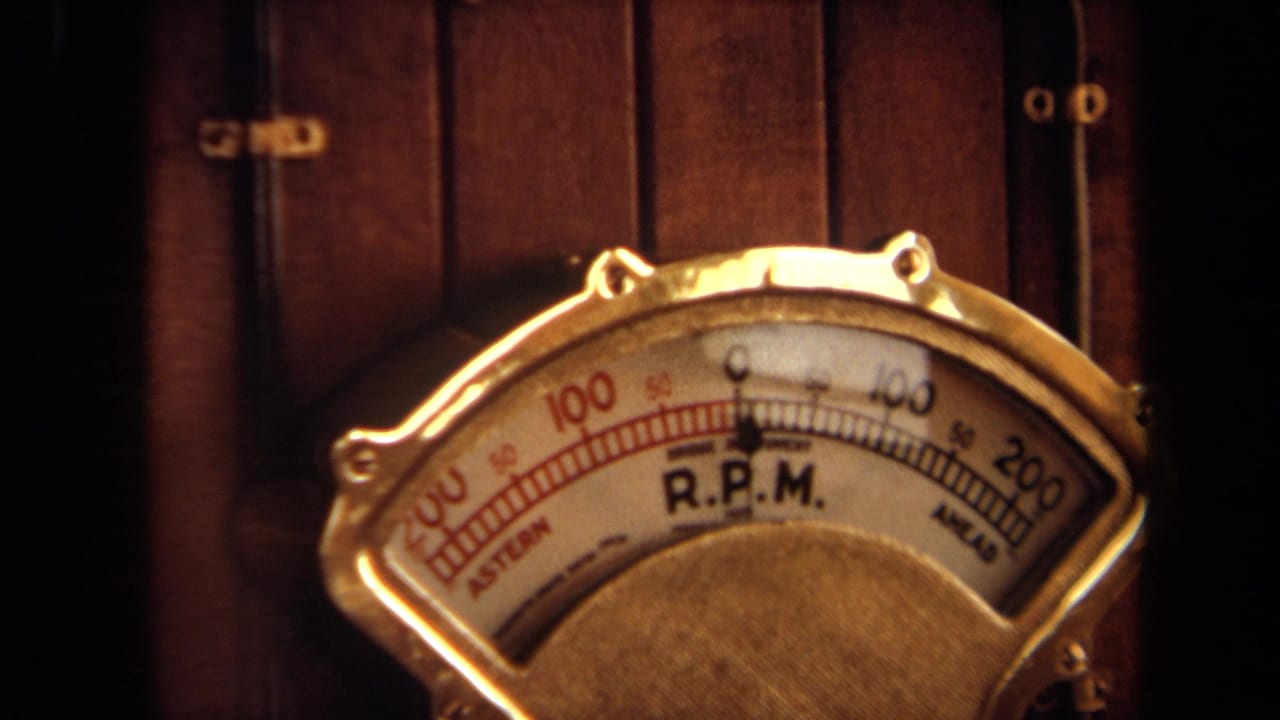 1971 8mm close-up of a brass-toned boat R.P.M. gauge with dark wood paneling behind it.
