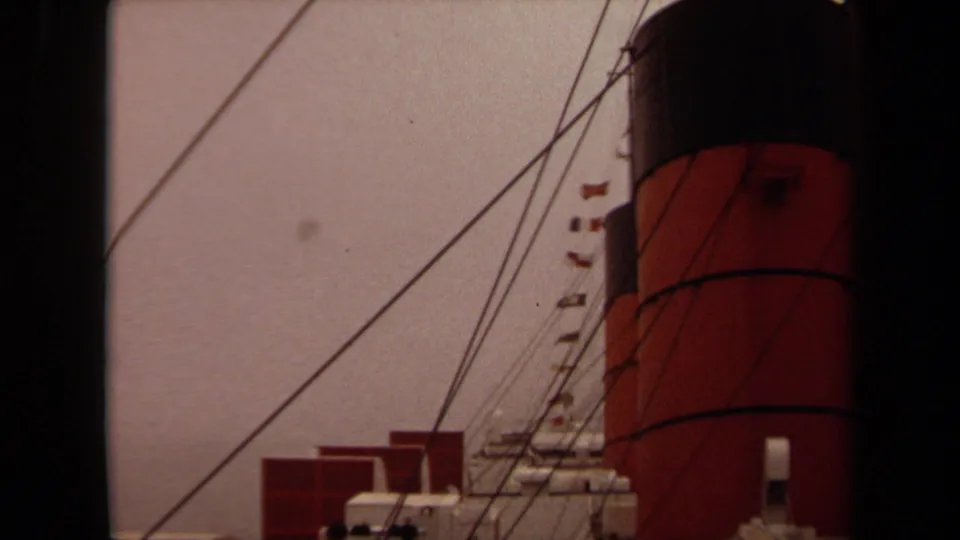 1971 Long Beach 8mm frame with ship funnel, diagonal lines, small flags, and deck equipment near the harbor.