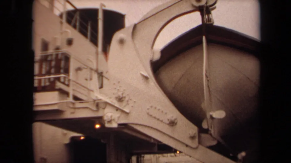 1971 Long Beach dockside frame with a white ship structure, suspended curved boat form, railings, riveted metal, and lower walkway.
